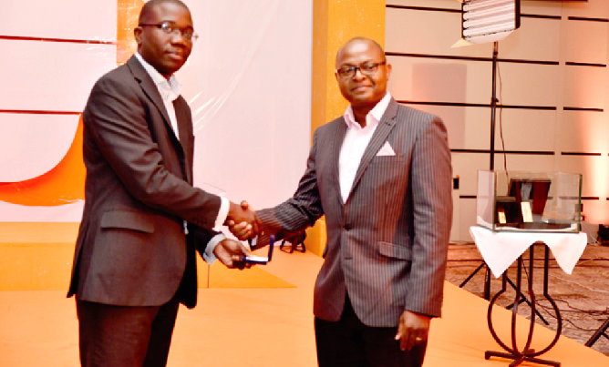 Julian Kingsley Opuni (left), Divisional Director for Retail Banking, presenting a gold coin to one of the  winners 